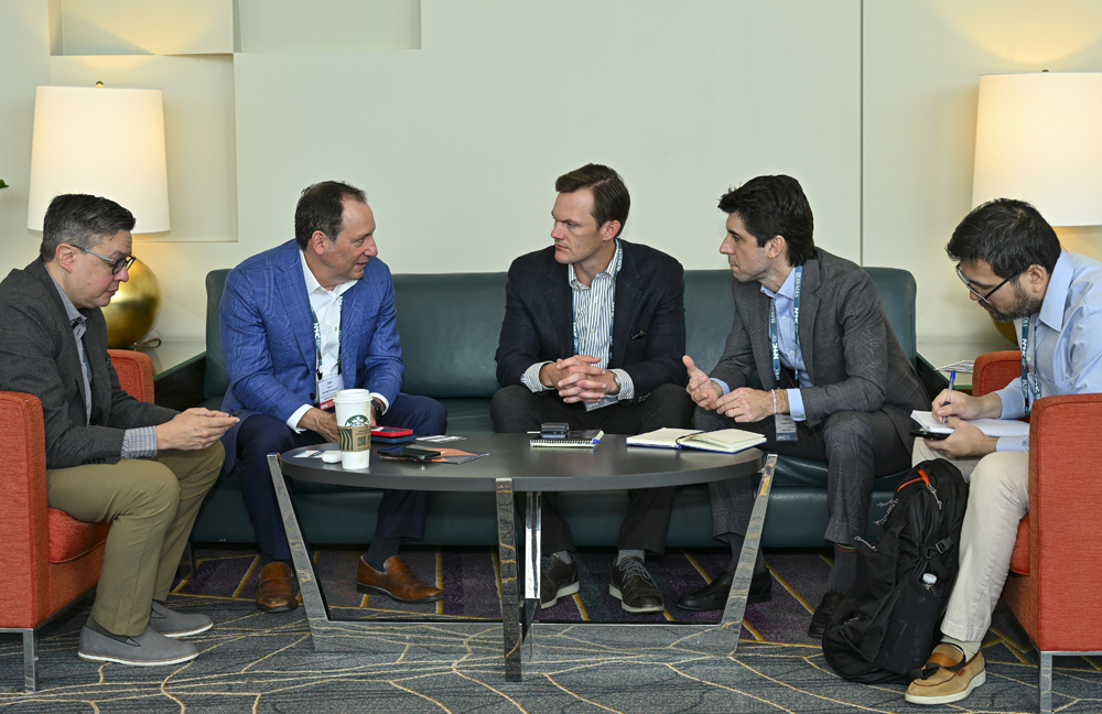 Event Sponsorships Men talking at a couch and chairs