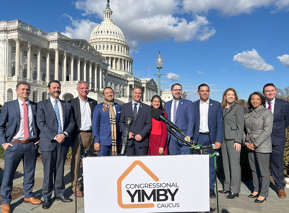 People standing in front of Capitol building with YIMBY sign in front of them